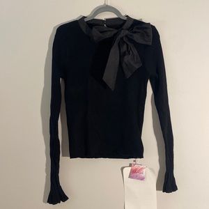 Beautiful long sleeve top with bow accent and trumpet sleeves